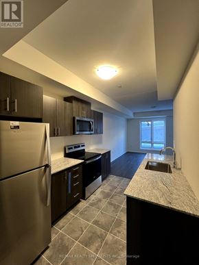 Toronto (Malvern) townhouse for rent - A kitchen with a refrigerator, microwave, and sink.
