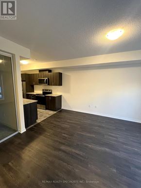 Toronto (Malvern) townhouse for rent - A room with a wooden floor and a microwave above the counter.