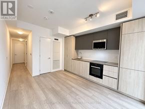 Toronto (Waterfront Communities) condo for rent - A modern kitchen with wooden cabinets and a stainless steel range hood.