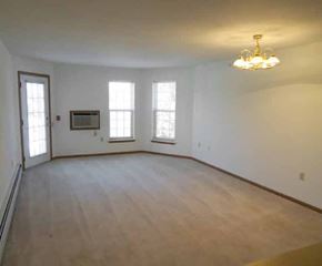 Cedarburg apartment for rent - an empty living room with a wood floor and a chandelier