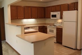 Cedarburg apartment for rent - a kitchen with white appliances and wooden cabinets