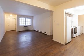 Cedarburg apartment for rent - an empty living room with a refrigerator and a window
