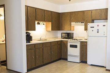 Cedarburg apartment for rent - a kitchen with white appliances and wooden cabinets