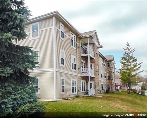 Cedarburg apartment for rent - a large apartment building with a yard and trees