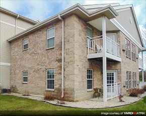 Cedarburg apartment for rent - a brick house with a balcony and a yard