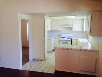 Lanacaster house for rent - A kitchen with white cabinets and a white stove.