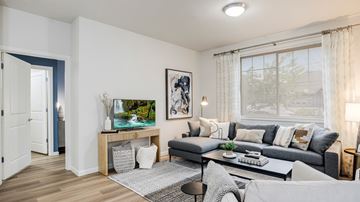 Beaverton apartment for rent - A living room with a grey couch, a coffee table, and a painting on the wall.