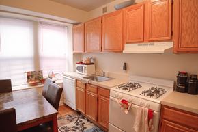 Orange apartment for rent - Kitchen and dining room with hardwood floors and wooden cabinets