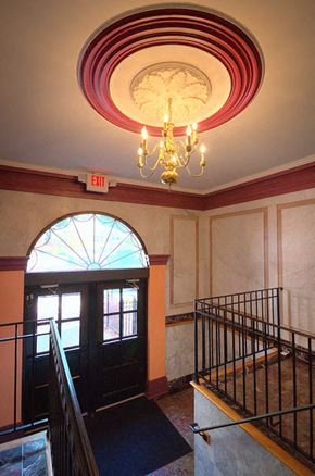 Orange apartment for rent - Entrance to property with golden chandelier above steps