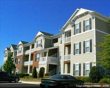 Garner apartment for rent - A large apartment building with a car parked in front.