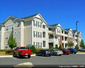 Garner apartment for rent - A red pickup truck is parked in front of a two-story apartment building.