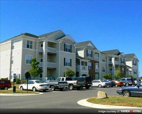 Garner apartment for rent - A row of apartment buildings with cars parked in front.