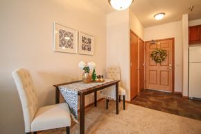 Sun Prairie apartment for rent - a dining room with a table and chairs and a hallway with a refrigerator