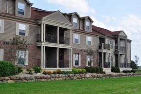Sun Prairie apartment for rent - the front of a large house with a yard and grass