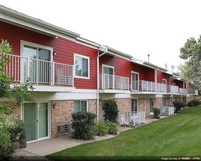 Madison apartment for rent - a red apartment building with balconies and a yard