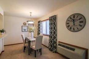 Madison apartment for rent - a dining room with a clock on the wall and a table and chairs