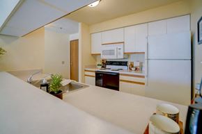 Sun Prairie apartment for rent - a kitchen with white cabinets and a sink and a refrigerator