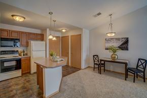 Sun Prairie apartment for rent - a kitchen and dining room with a table and chairs and a refrigerator