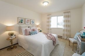 Fitchburg apartment for rent - a bedroom with a white bed and a window