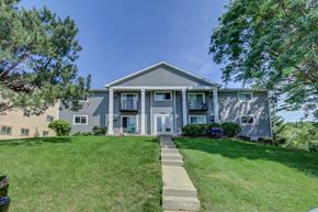 Fitchburg apartment for rent - the front of a blue house with a lawn and trees