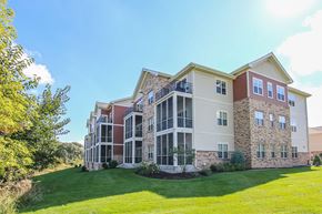 Madison apartment for rent - an exterior view of an apartment building with a green lawn