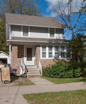 Madison triplex for rent - a house with a moped parked in front of it
