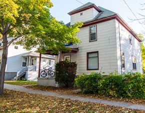 Madison triplex for rent - a white house with a bike parked outside of it