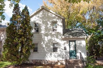 Madison triplex for rent - the front of a white house with a green door and trees