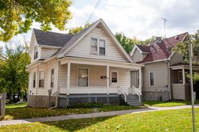 Madison triplex for rent - a white house with a porch and a sidewalk in front of it