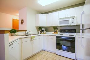 Fitchburg apartment for rent - a kitchen with white cabinets and stainless steel appliances