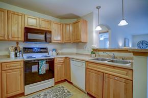 Deforest apartment for rent - a kitchen with wooden cabinets and a stove and a sink