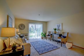 Deforest apartment for rent - a living room with a couch and chairs and a sliding glass door
