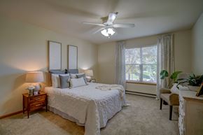 Deforest apartment for rent - a bedroom with a large bed and a ceiling fan