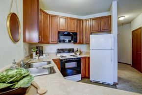 Madison apartment for rent - a kitchen with white appliances and wooden cabinets