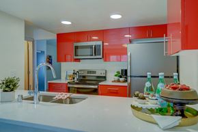 Madison townhouse for rent - a kitchen with red cabinets and a white counter top and a sink