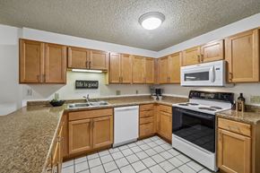 Madison apartment for rent - A kitchen with brown cabinets and white appliances.
