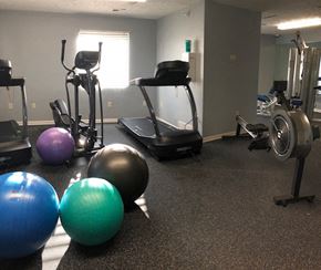 Omaha apartment for rent - a gym with cardio equipment and weights on the floor