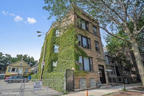 Chicago apartment for rent - a building covered in ivy on the side of a street