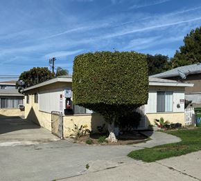 Harbor City triplex for rent - A large green hedge covers the top of a house.