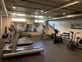Eau Claire apartment for rent - a gym with cardio equipment and weights in a building