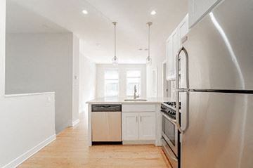 Chicago apartment for rent - a kitchen with stainless steel appliances and white cabinets