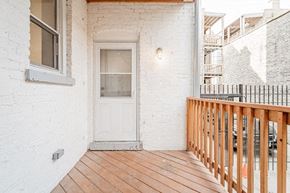 Chicago apartment for rent - a porch with a white door and a wooden railing