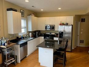 Chicago apartment for rent - a kitchen with stainless steel appliances and white cabinets