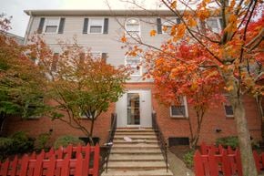 Orange apartment for rent - Exterior of building with red picket fence