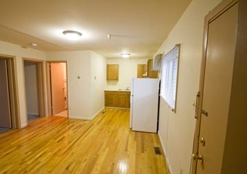 Orange apartment for rent - a kitchen with a white refrigerator and a wooden floor