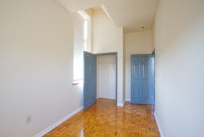 Newark apartment for rent - Bedroom with hardwood floors, white walls, and closet with blue doors