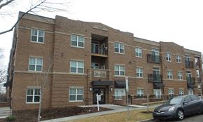 Rochester apartment for rent - a brick apartment building with a car parked in front