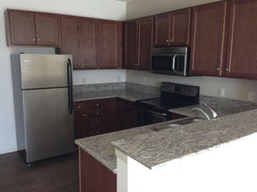 Rochester apartment for rent - a kitchen with granite counter tops and a stainless steel refrigerator