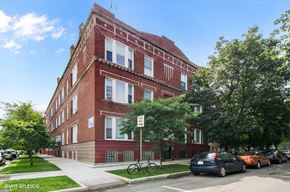 Chicago apartment for rent - A red brick building with a bicycle parked in front.