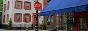 New York apartment for rent - a stop sign on a pole in front of a building